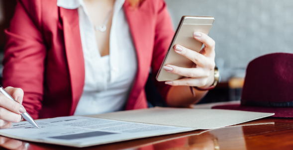 A woman in a pink blazer using her mobile phone