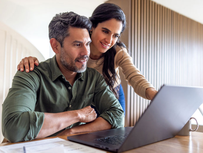 a couple looking at their laptop computer