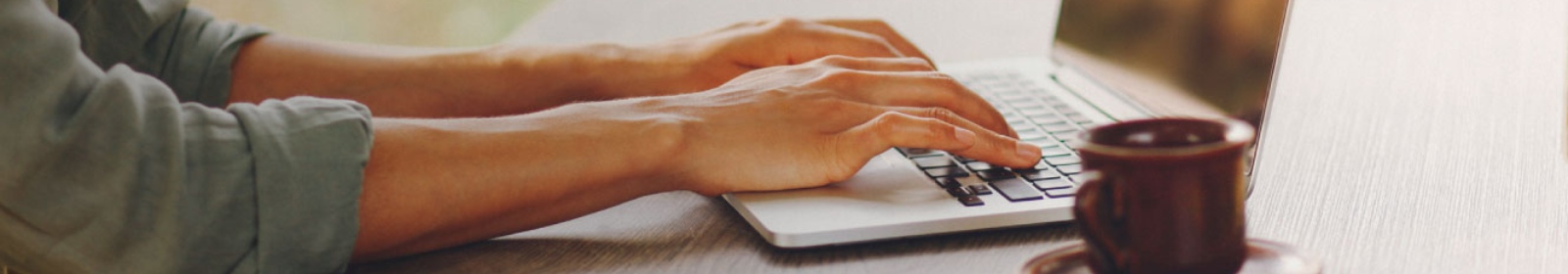 a person typing on their laptop computer